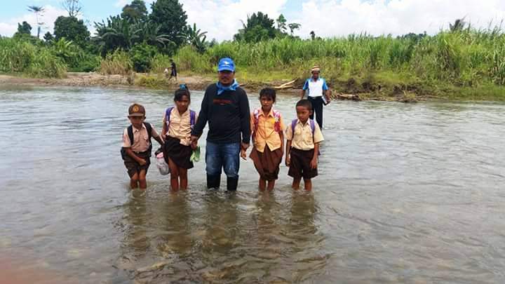 Uksin saat Menyeberang Sungai Bersama Anak Sekolah